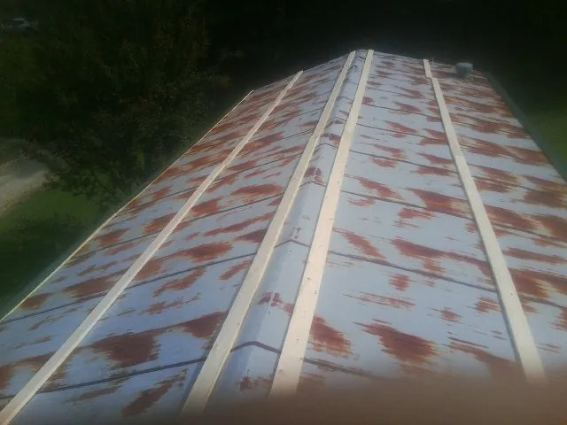 Rusted metal roof panels with new wood purlins before replacement — Storm Damage Roof Repair in Palenville by Roofing Brothers