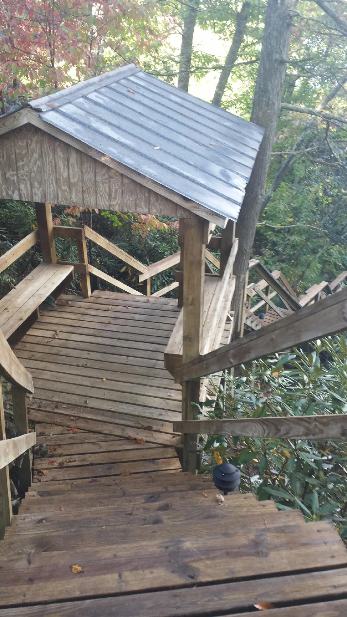 Metal roofed shelter over wooden steps on a wooded walkway — Skylight Repair & Installation work by our crew in Palenville